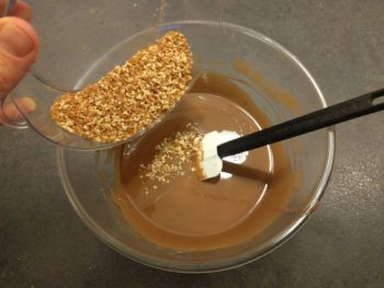 Faire fondre progressivement les chocolats et beurre de cacao puis ajouter les pralinés grains
