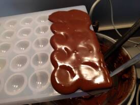 Remplir le moule propre de chocolat tempéré puis tapoter sur le coté pour faire sortir les bulles d'air