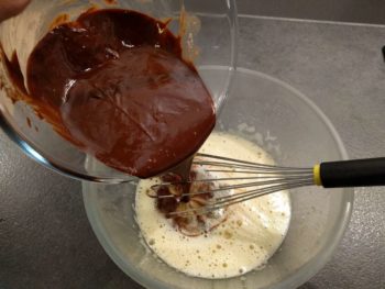 Faire fondre le chocolat doucement avec le beurre puis verser ce mélange tiède sur les œufs blanchis. Mélanger soigneusement au fouet.