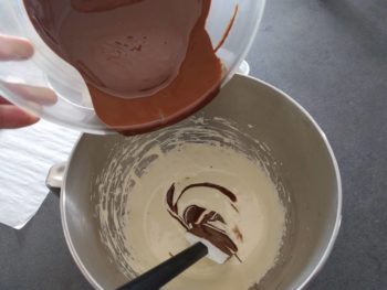 Verser le chocolat en plusieurs fois du chocolat sur la pâte à bombe et à chaque fois, mélanger avec la maryse