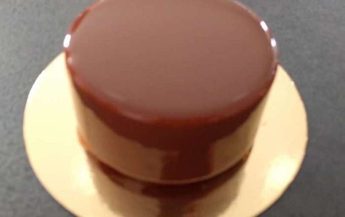 Glaçage miroir au chocolat au lait appliqué sur un entremets