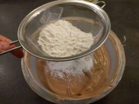 Enfin, ajouter la farine tamisée et remuer toujours délicatement