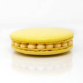 Gros macaron individuel fourré d'une crème diplomate au fruit de la passion et de morceaux d'ananas crus et caramélisés