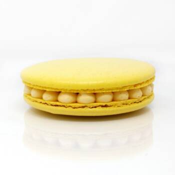 Gros macaron individuel fourré d'une crème diplomate au fruit de la passion et de morceaux d'ananas crus et caramélisés