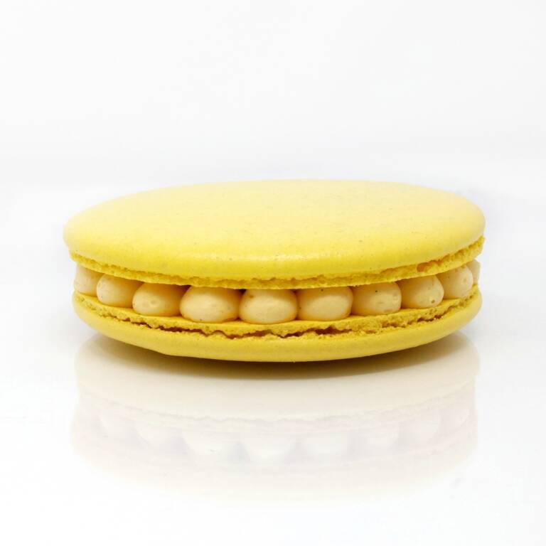 Gros macaron individuel fourré d'une crème diplomate au fruit de la passion et de morceaux d'ananas crus et caramélisés