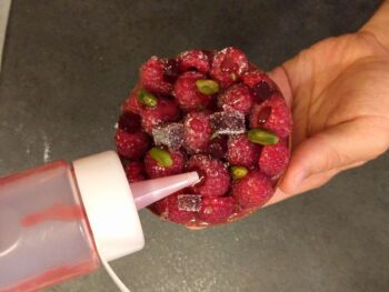 Garnir quelques framboises de purée de framboises