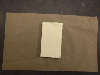 Enfermer votre beurre dans un papier cuisson à une taille de moitié par rapport à la détrempe