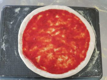 Déposer une fine couche de sauce tomate sur votre pizza maison