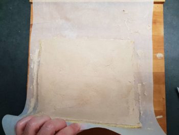 Commencer à rouler la bûche en s'aidant du papier cuisson sous la bûche