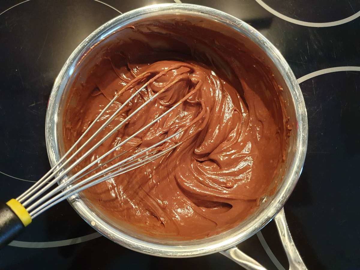 Dès que le chocolat est presque fondu, fouettez vigoureusement pour obtenir une belle crème pâtissière lisse et brillante