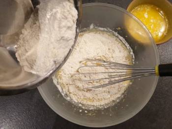 Ajouter progressivement la farine et la levure tamisée et mélanger doucement au fouet