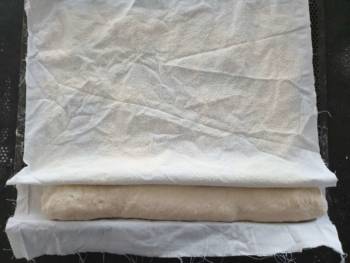 Déposer votre baguette à l'envers sur un tissu bien fariné (une couche). Bien serrer le pain pour qu'il pousse de manière uniforme. Pour une miche, déposer dans une banneton.