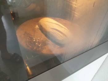 Faire glisser le pain au centre de la plaque de cuisson chaude, verser de l'eau dans le bas du four et refermer rapidement