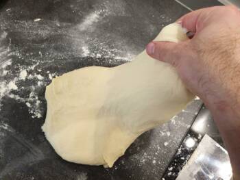 Déposer la pâte sur le plan de travail et faire quelques rabats : soulever une partie de la pâte