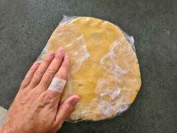 Séparer la pâte en deux (environ 3/5eme et 2/5eme). Pré-étaler la pâte et la filmer au contact.