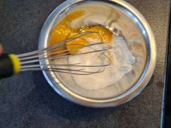 En parallèle, blanchir les jaunes avec le sucre et la poudre à crème