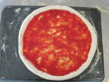 Déposer une fine couche de sauce tomate réduite sur votre pizza maison