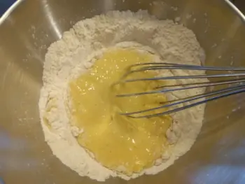 Ajouter les œufs dans le puits, mélanger au fouet