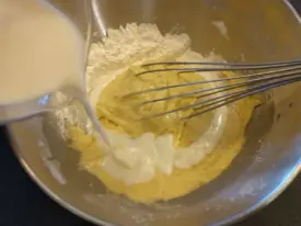 Verser le beurre fondu, mélanger, puis un peu de lait