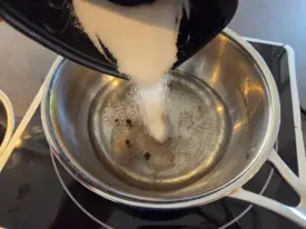 Verser l'eau, le sucre et éventuellement de la poudre de vanille dans votre casserole