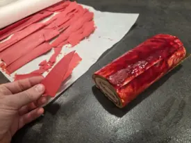 Coller des plaques fines de chocolat blanc teinté framboise façon écorce et ajouter quelques meringues