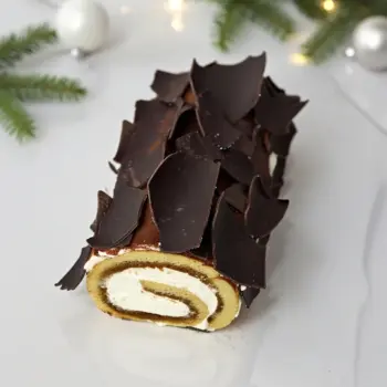 bûche tiramisu roulée décorée de chocolat noir, ambiance Noël lumineuse